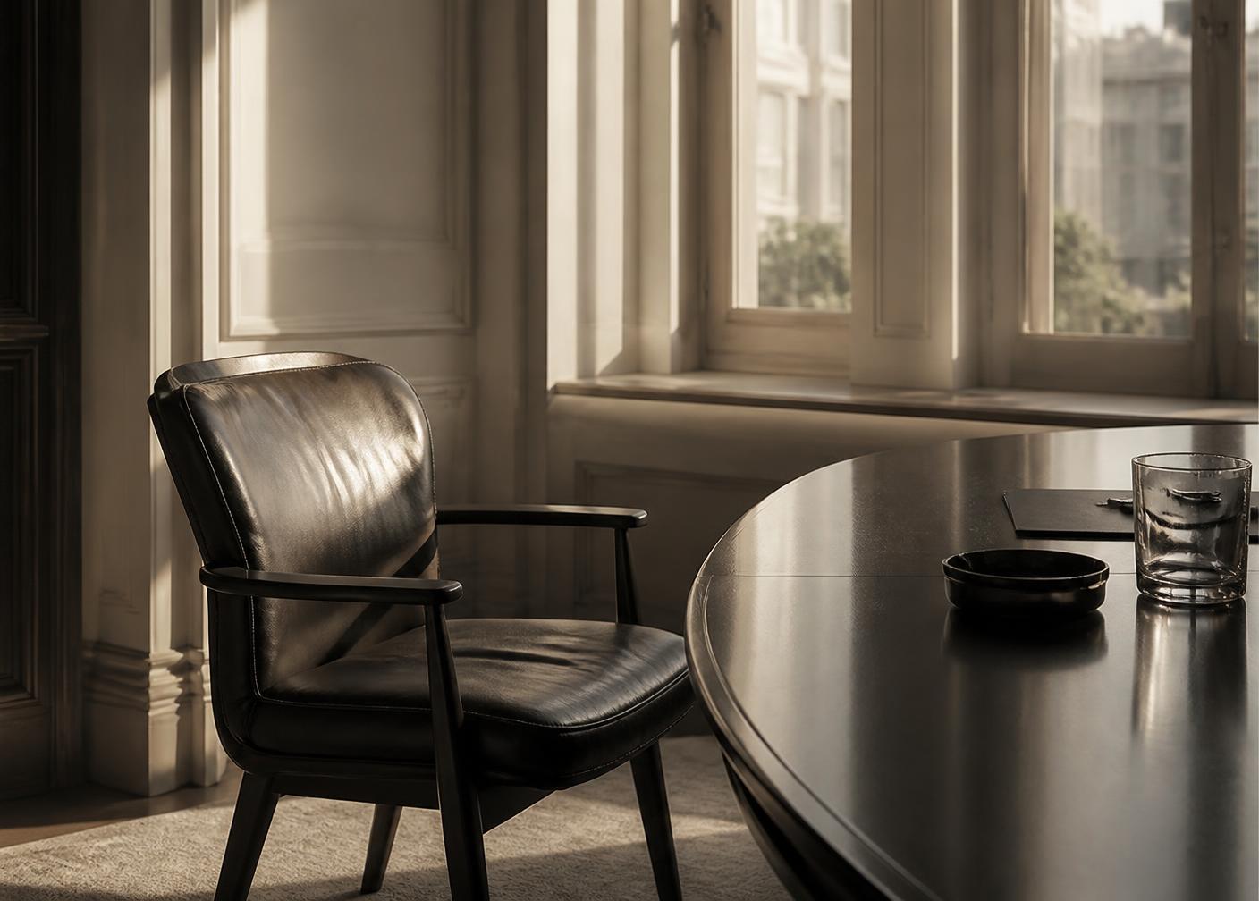 A chair pulled up to a dark meeting table